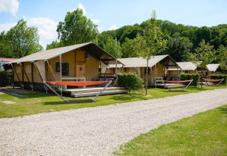 Safari telte ved Villatent Nomad på Camping 't Geuldal i Holland, omgivet af grønne træer og hængekøjer.