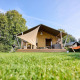 Safaritent Villatent Nomad op Camping de Papillon in Nederland, met hangmat en groene grasmat.