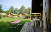 Glampingområde med safaritelt Villatent Nomad og hængekøje på Camping de Papillon i Holland, omgivet af natur.