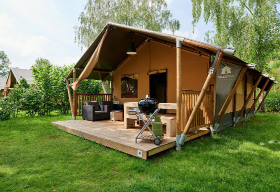 Safaritent Villatent Nomad met veranda en barbecue bij Parc de Witte Vennen, Nederland, omgeven door natuur.