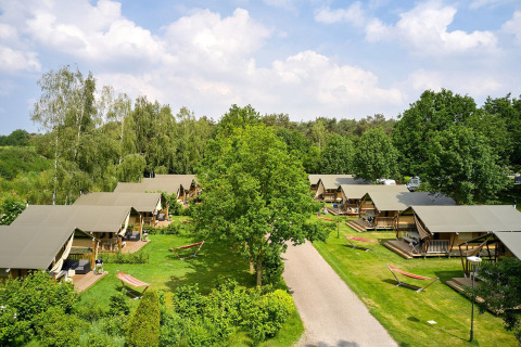 Vista aérea de tiendas safari Villatent Nomad en Parc de Witte Vennen, rodeadas de vegetación en los Países Bajos.