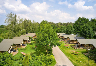 Vista aérea de tiendas safari Villatent Nomad en Parc de Witte Vennen, rodeadas de vegetación en los Países Bajos.