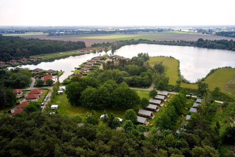 Luchtfoto van safaritenten en vakantiehuizen aan het meer bij Parc de Witte Vennen, Nederland.