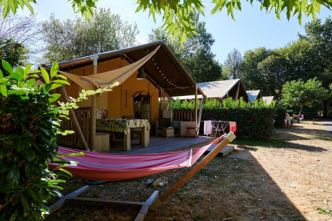 Safari-Zelt Villatent Nomad auf Camping Domaine du Logis in Frankreich mit Hängematte und Terrasse.