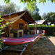Tienda safari Villatent Nomad en Camping Domaine du Logis, Francia, con hamaca y terraza al aire libre.