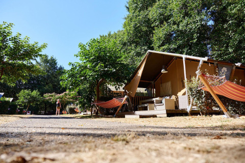 Safari-Zelt Villatent Nomad auf Camping Domaine du Logis in Frankreich, mit Hängematten und Bäumen.