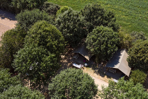 Vista aérea de la tienda safari Villatent Nomad entre árboles en el Camping La Bretonnière, Francia.