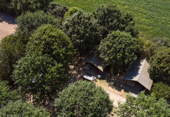 Vista aérea de la tienda safari Villatent Nomad entre árboles en el Camping La Bretonnière, Francia.