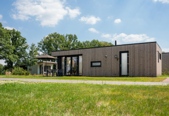 Oak lodge ved Vakantiepark Hölte i Holland, moderne træhytte med terrasse under blå himmel.
