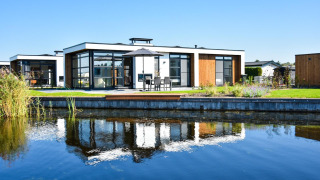 Villa moderna junto al agua, con ventanas de vidrio y terraza en MarinaPark Residentie Nieuw Loosdrecht, Países Bajos.