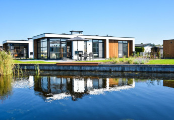 Villa moderna junto al agua, con ventanas de vidrio y terraza en MarinaPark Residentie Nieuw Loosdrecht, Países Bajos.