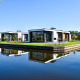 Modernas villas frente al agua en Villa Nautica Lodge, rodeadas de naturaleza y reflejadas en el agua tranquila.