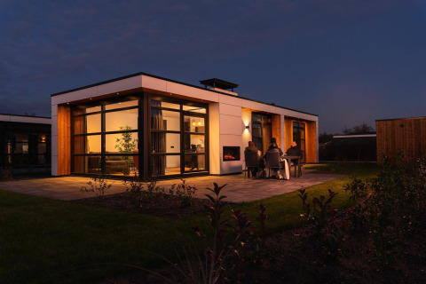 Foto nocturna de Villa Nautica en MarinaPark Residentie Nieuw Loosdrecht, huéspedes cenando fuera.