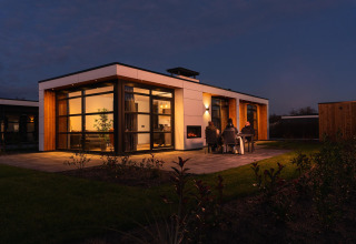 Foto nocturna de Villa Nautica en MarinaPark Residentie Nieuw Loosdrecht, huéspedes cenando fuera.