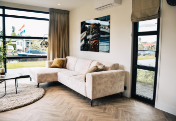 Salon moderne à la Villa Nautica, MarinaPark Residentie Nieuw Loosdrecht, Pays-Bas, avec canapé clair.