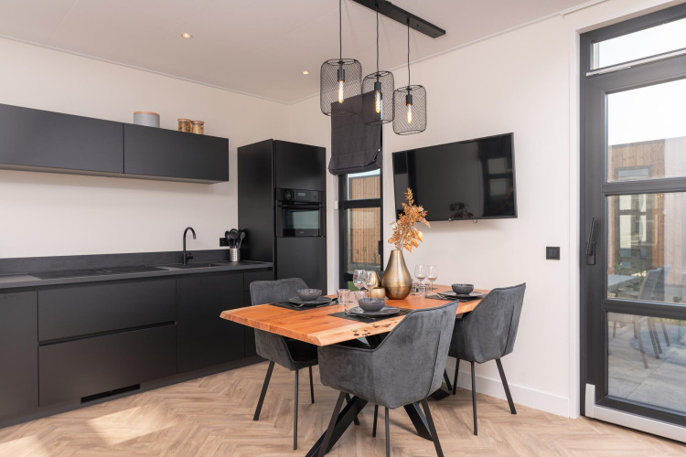 Moderne Lodge-Küche im Villa Nautica mit schwarzer Einrichtung, Esstisch und stilvollen Lampen.