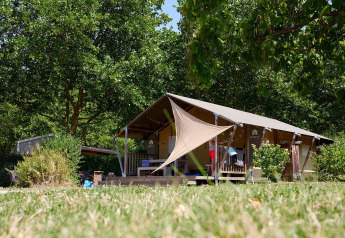 Safaritent Villatent Nomad op Camping Les Bois du Bardelet in Frankrijk, omgeven door bomen en groen.