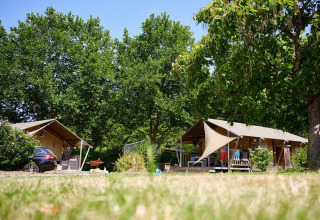 Safaritenten bij Villatent Nomad op Camping Les Bois du Bardelet in Frankrijk, omringd door groen.