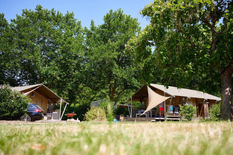 Safari-telte ved Villatent Nomad på Camping Les Bois du Bardelet i Frankrig, omgivet af træer og natur.
