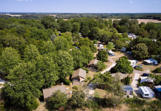 Vista aérea de la tienda safari Villatent Nomad en Camping Les Bois du Bardelet, Francia, rodeada de árboles.