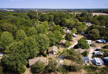 Vista aérea de la tienda safari Villatent Nomad en Camping Les Bois du Bardelet, Francia, rodeada de árboles.