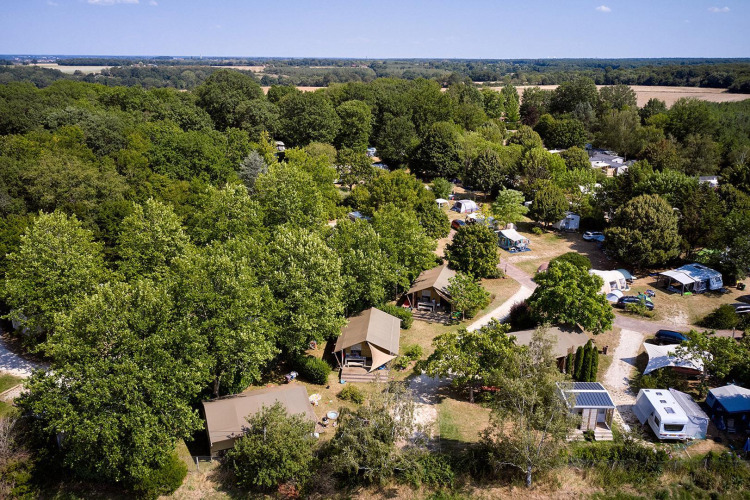 Vista aérea de la tienda safari Villatent Nomad en Camping Les Bois du Bardelet, Francia, rodeada de árboles.
