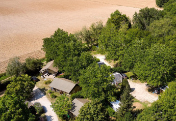 Vista aérea de Villatent Nomad en Camping Les Bois du Bardelet en Francia, rodeado de árboles y campos abiertos.