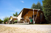 Tiendas safari Villatent Nomad en Camping La Roche d’Ully, Francia, en un día soleado y cielo azul.