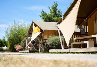 Tiendas safari Villatent Nomad en Camping La Roche d’Ully, Francia, rodeadas de vegetación y sol.