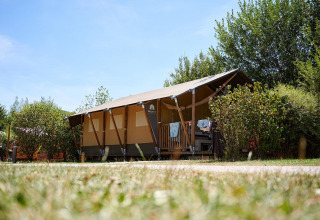 Tienda safari Villatent Nomad en Camping La Roche d’Ully, Francia, rodeada de vegetación y naturaleza.
