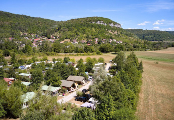 Luchtfoto van een Villatent Nomad safaritent op Camping La Roche d’Ully in Frankrijk, tussen groene heuvels.