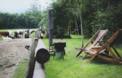 Idyllisk udsigt ved Feather Down De Lange Weide med liggestole, grill og køer på en grøn eng i Drenthe.