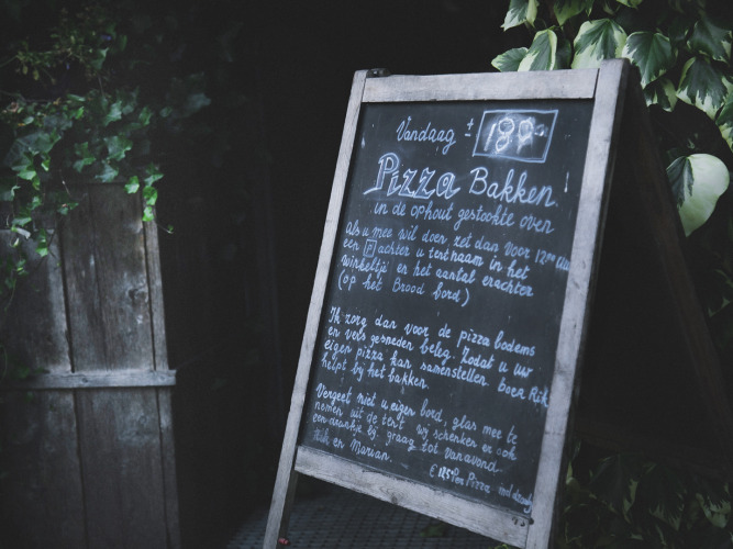 Ardoise extérieure annonçant la cuisson de pizzas à Feather Down De Lange Weide, parc de vacances à Drenthe, Pays-Bas.