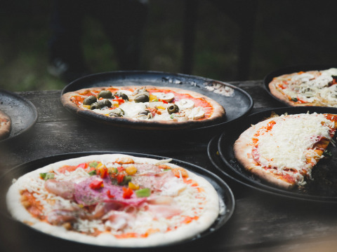 Pizzas recién hechas con variados ingredientes servidas en bandejas en Feather Down De Lange Weide, Drenthe.