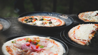 Pizzas recién hechas con variados ingredientes servidas en bandejas en Feather Down De Lange Weide, Drenthe.