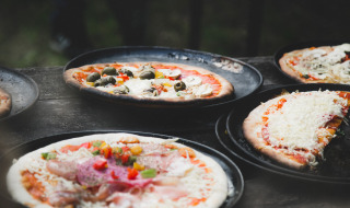 Pizzas recién hechas con variados ingredientes servidas en bandejas en Feather Down De Lange Weide, Drenthe.