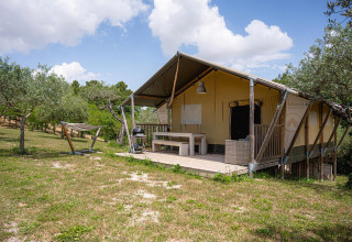 Tienda safari Villatent Nomad en Camping Pian Di Boccio, Italia, con terraza, hamaca y área exterior verde.