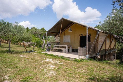 Tienda safari Villatent Nomad en Camping Pian Di Boccio, Italia, con terraza, hamaca y área exterior verde.