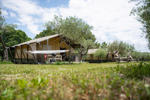 Safari-telte, Villatent Nomad, på Camping Pian Di Boccio i Italien, blandt træer på en solrig dag.