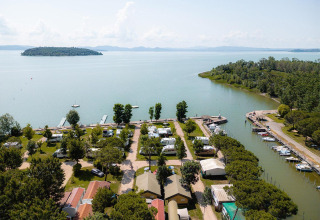 Luchtfoto van de Villatent Nomad safaritent op Camping Punta Navaccia aan het meer in Italië, omgeven door groen.