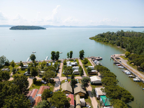 Luchtfoto van de Villatent Nomad safaritent op Camping Punta Navaccia aan het meer in Italië, omgeven door groen.