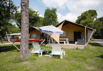 Tenda safari Villatent Nomad con lettini, ombrellone e amaca al Camping Punta Navaccia in Italia.