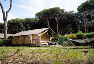 Safaritent Villatent Nomad op Camping Roma Capitol in Italië, omringd door bomen en groene natuur.