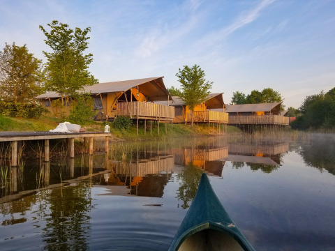 Tentes safari au bord du lac au parc Eigen Wijze aux Pays-Bas, vues depuis un canoë sur l'eau.