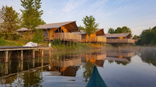 Tentes safari au bord du lac au parc Eigen Wijze aux Pays-Bas, vues depuis un canoë sur l'eau.