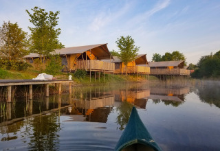 Tiendas safari junto al lago en Holiday Park Eigen Wijze, Países Bajos, vistas desde una canoa en el agua.