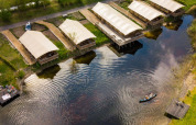 Aerial view of safari tents by the lake at Holiday Park Eigen Wijze, Netherlands, with a canoe.