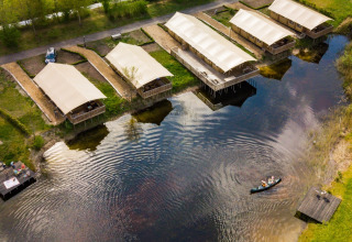 Vue aérienne des tentes safari près d’un lac au Holiday Park Eigen Wijze, Pays-Bas, avec un canoë.