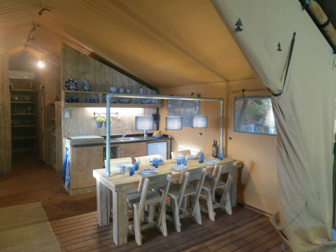 Innenansicht eines Safari-Zeltes mit Küche und Essbereich im Holiday Park Eigen Wijze, Niederlande.