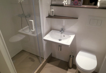 Modern bathroom in safari tent with shower, sink, and toilet at Holiday park Eigen Wijze, Netherlands.